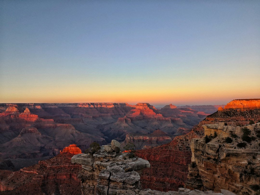 Warm evening light spreading across the layered cliffs of the Grand Canyon
