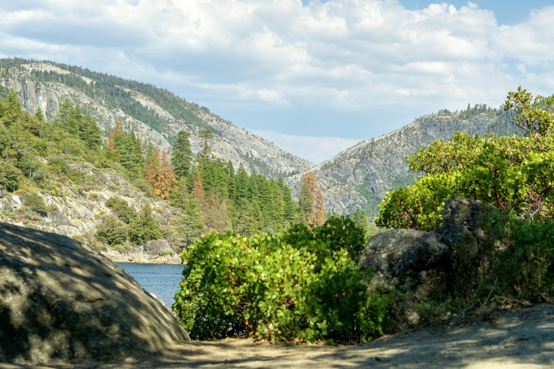 An alpine lake reflecting the granite mountains and forests of Yosemite National Park